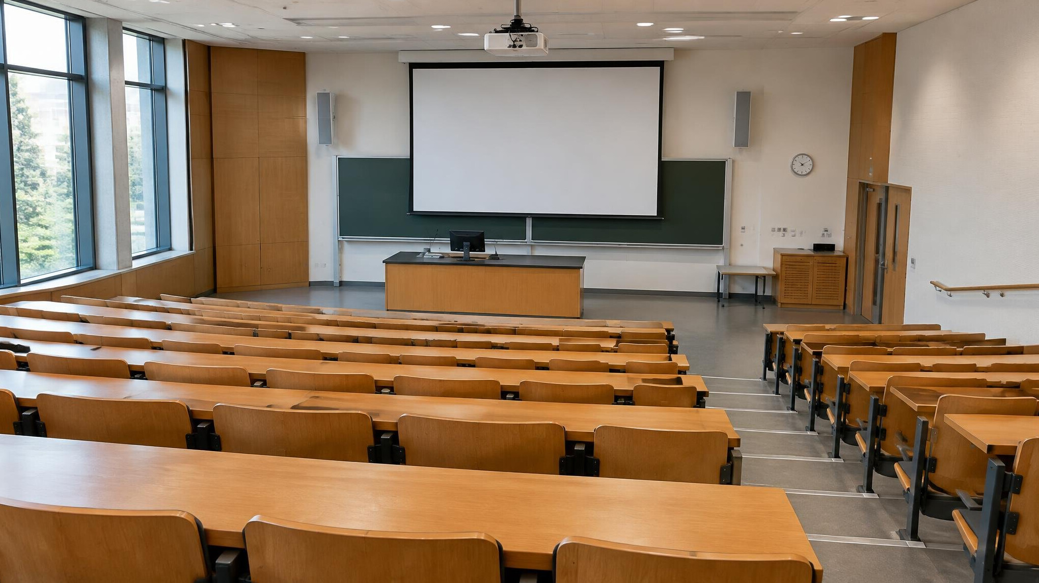 Lecture hall with rows of seats and a presentation screen